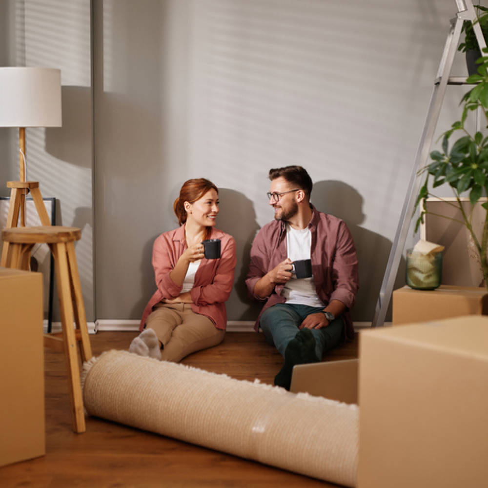 Happy couple drinking coffee while taking a break from moving into new home